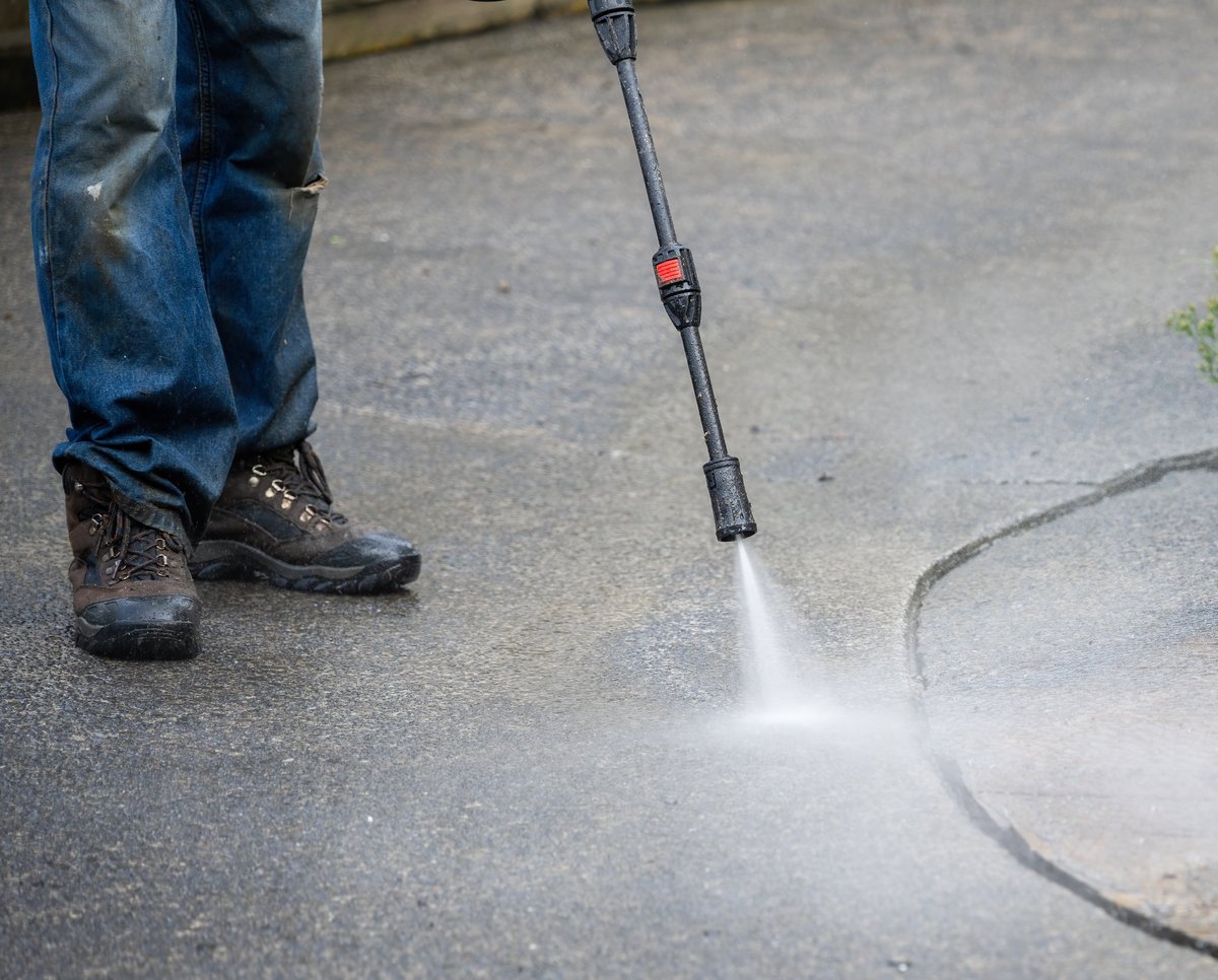 Professional pressure washing worker cleaning pavement